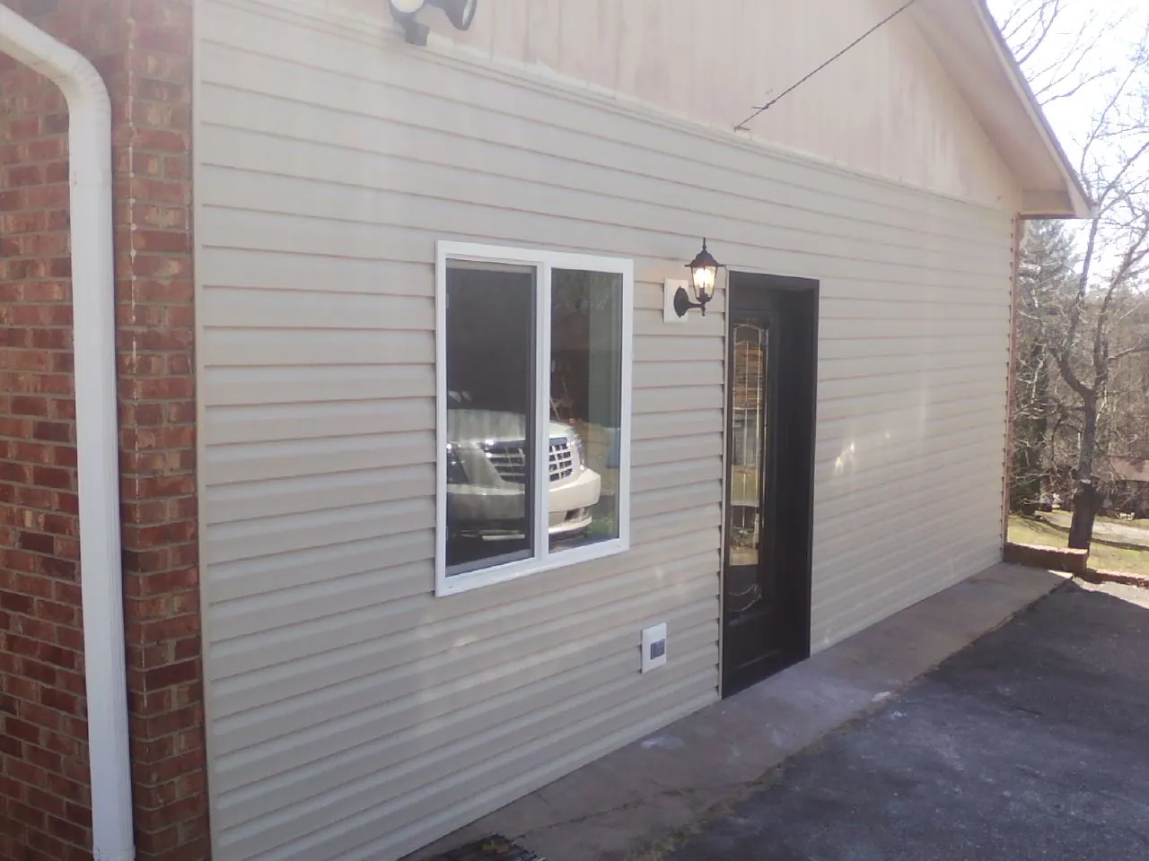 New vinyl siding and entry door on a room addition in New Canton