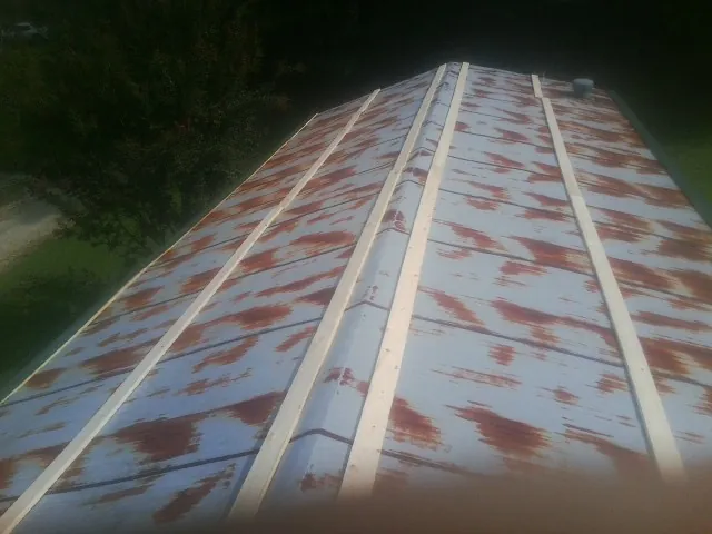 Rusted metal roof panels with new wood purlins before replacement — Storm Damage Roof Repair in New Canton by Roofing Brothers