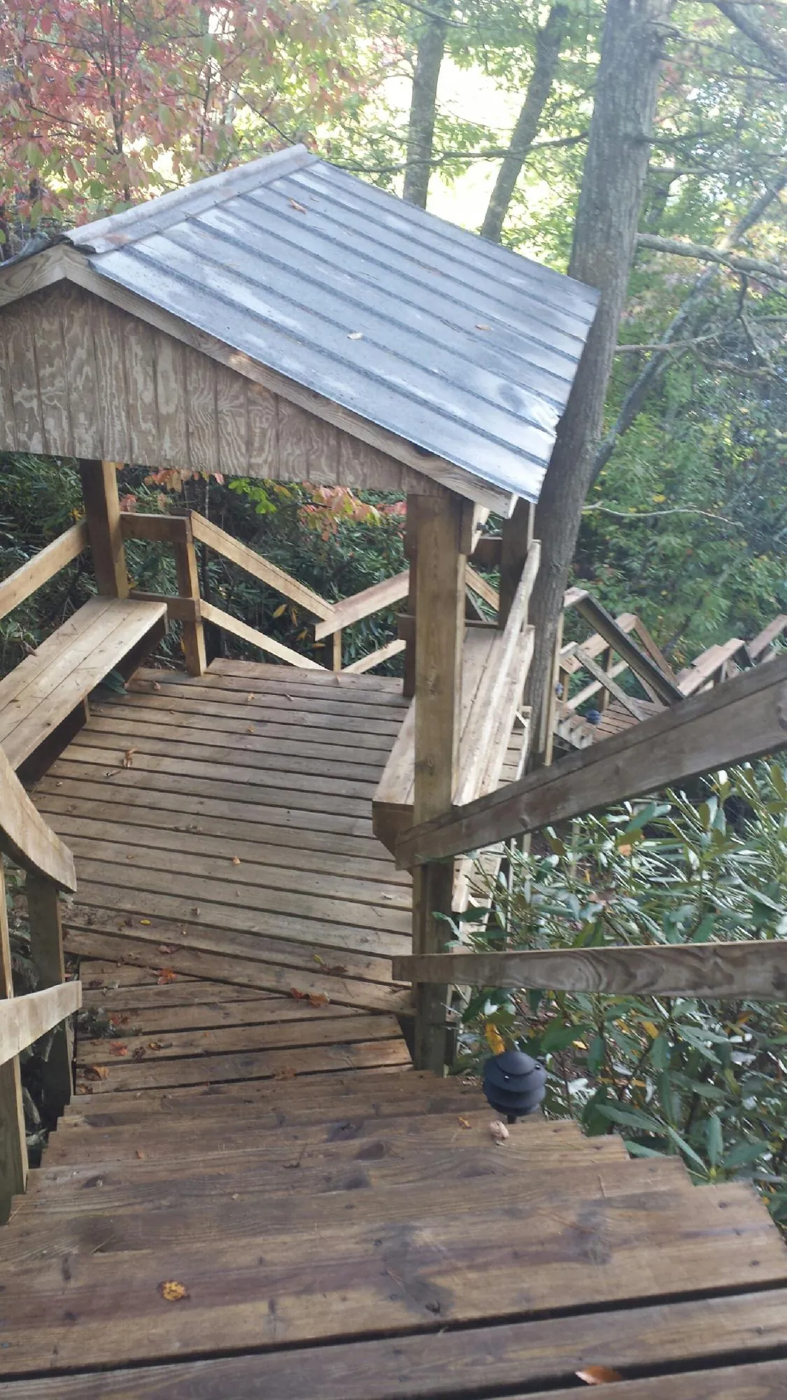 Metal roofed shelter over wooden steps on a wooded walkway — Skylight Repair & Installation work by our crew in New Canton