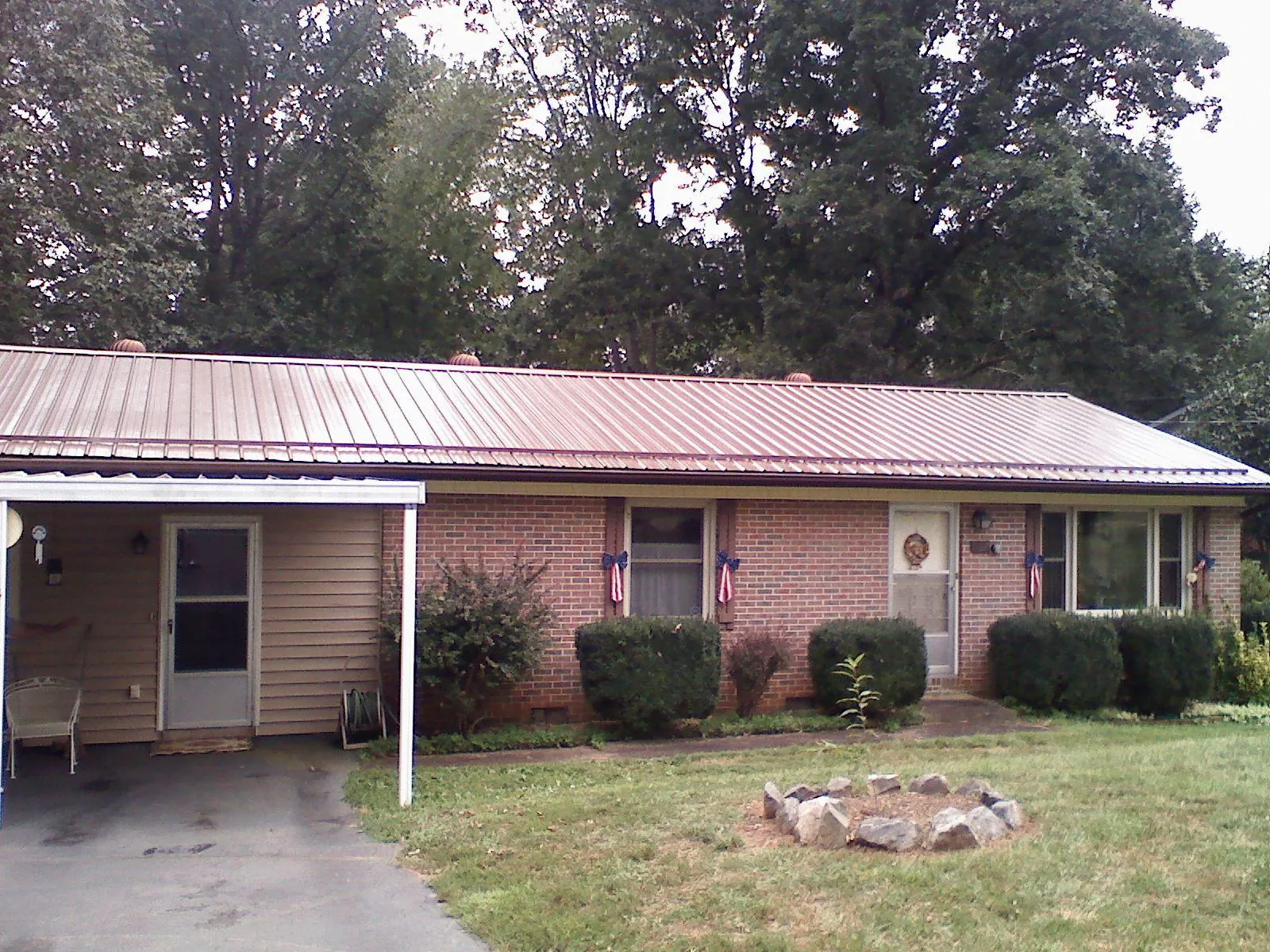 Bronze metal roof and carport on a brick ranch home — Roof Repair work by our crew in New Canton